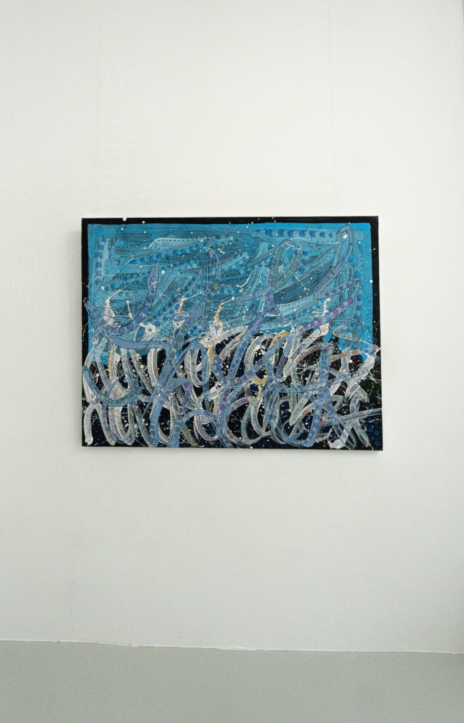 Œuvre de JonOne aux dominantes bleues, traversée de lignes blanches et grises, accrochée sur un mur blanc.