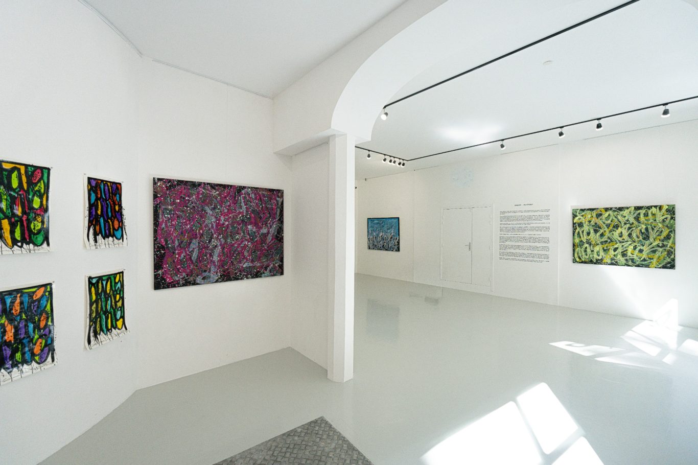 Vue des salles de H.D Galerie avec une œuvre rose au premier plan et plusieurs œuvres sur les murs du fond.